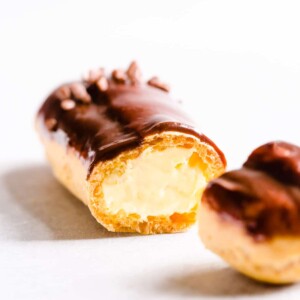 Sliced chocolate eclair filled with pastry cream.