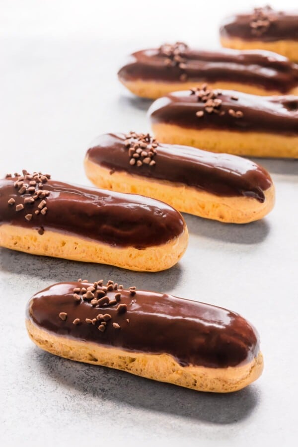 Chocolate eclairs on a counter.