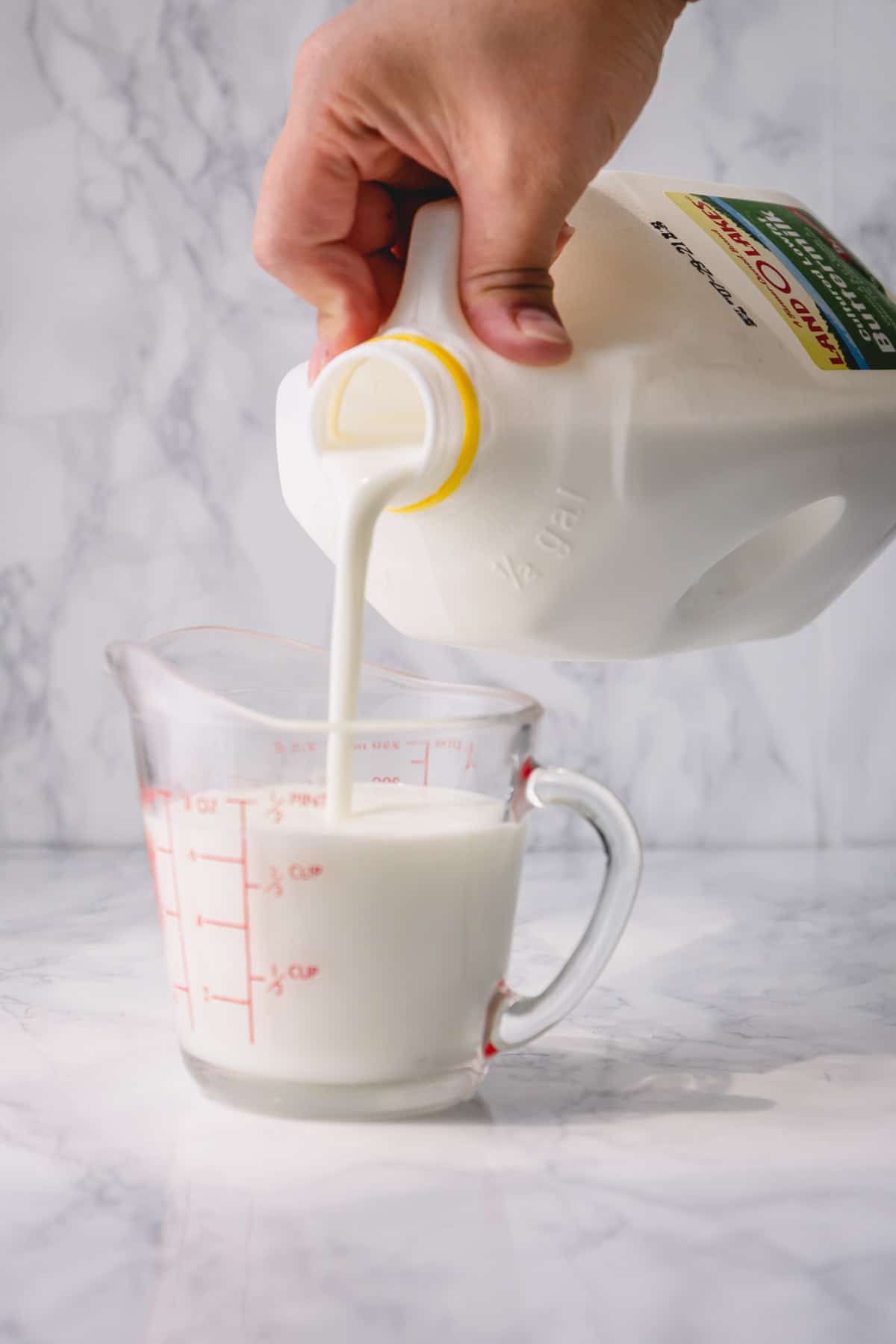 Buttermilk poured into a measuring cup.