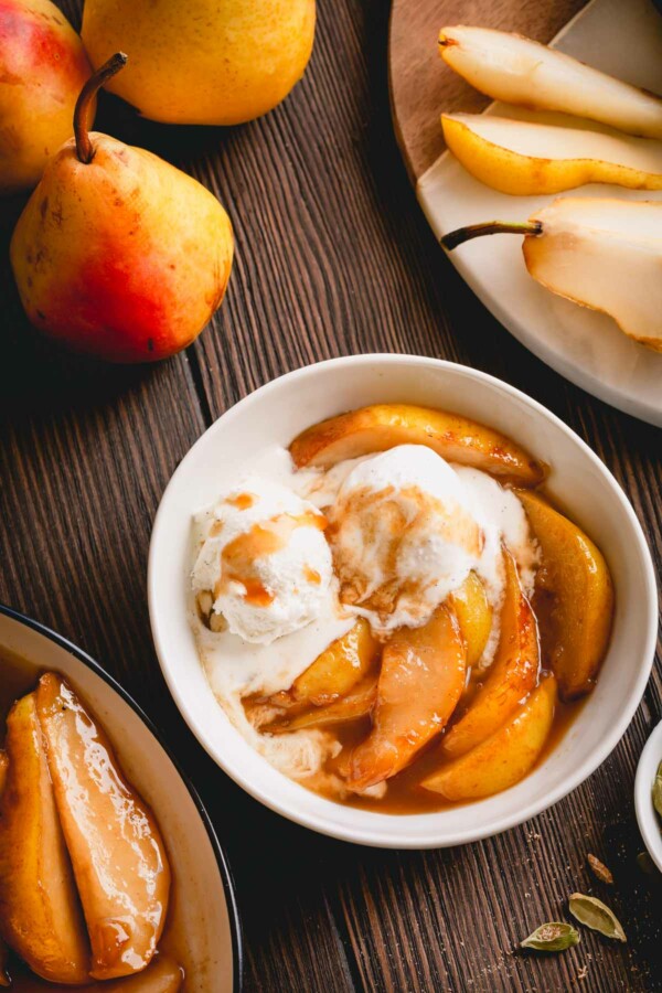 Caramelized pear slices with vanilla ice cream in a small bowl.