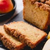 Closeup shot of pear bread slices on black cutting board.