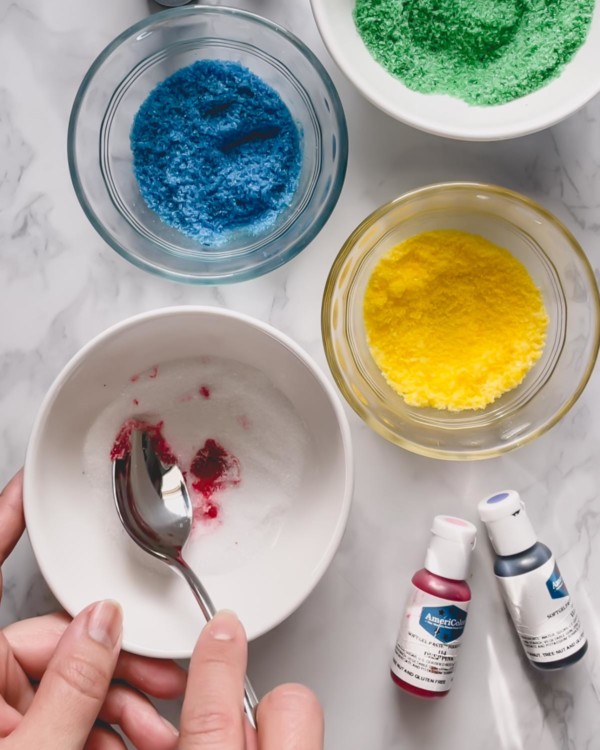 Mixing in food coloring into granulated sugar.