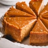 sliced dulce de leche cheesecake on a white serving platter.