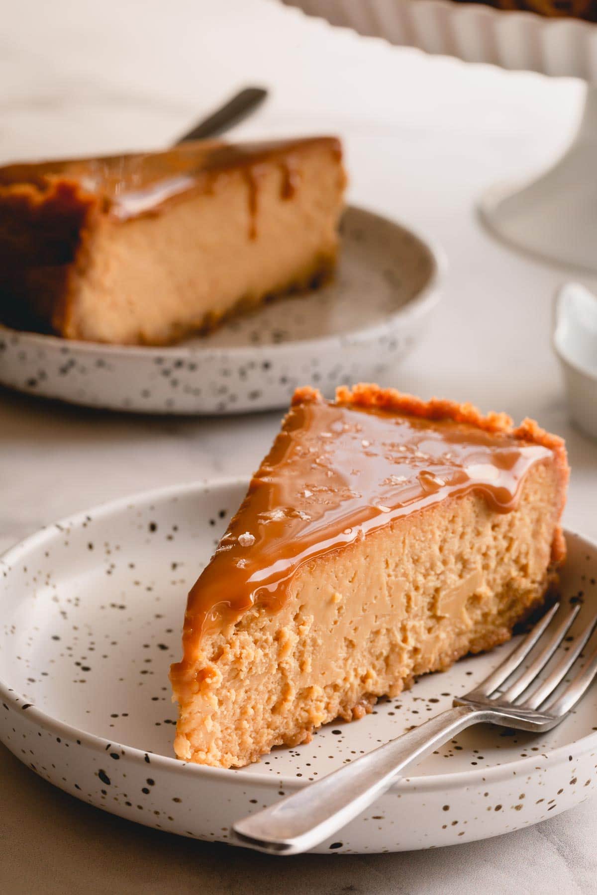 A slice of dulce de leche cheesecake on a small plate.