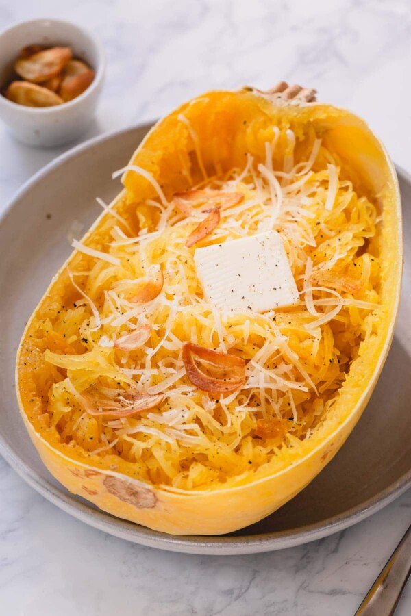 Half of baked spaghetti squash with butter and parmesan cheese.