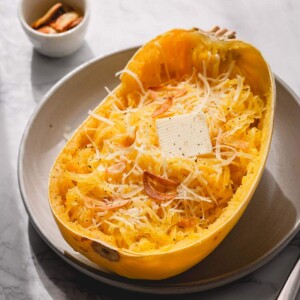 Half of baked spaghetti squash with butter and parmesan cheese.