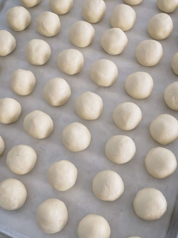 White cake balls on a baking sheet.
