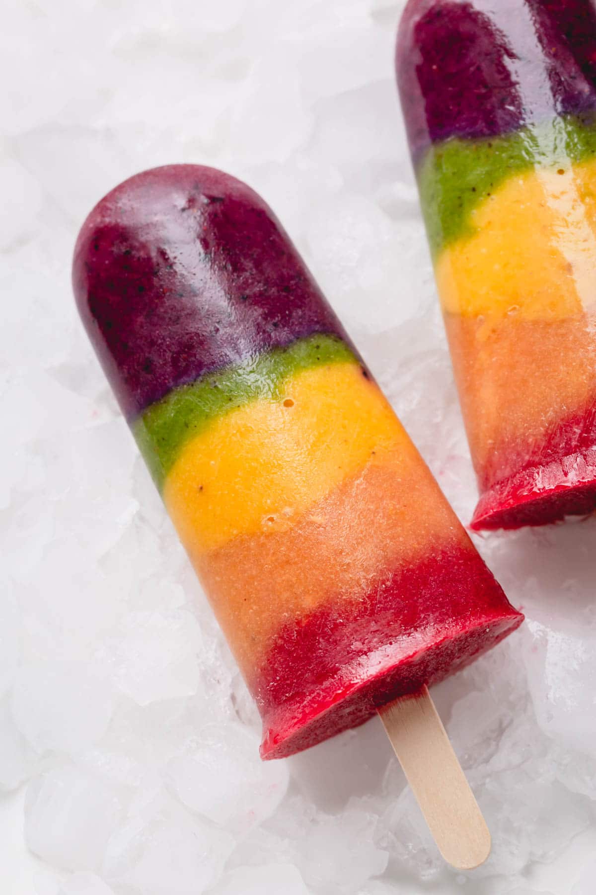 Rainbow popsicles over crushed ice.