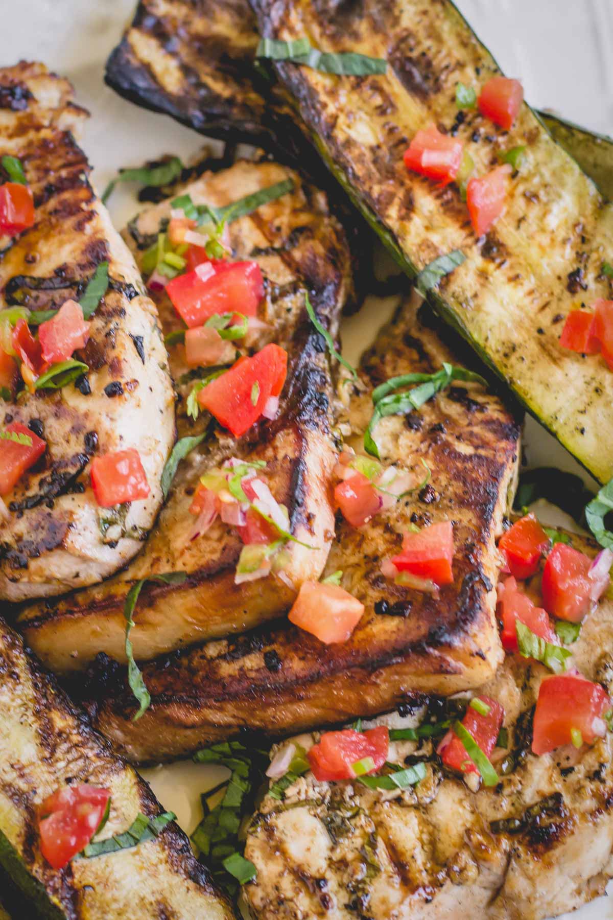 Grilled swordfish steaks topped with chopped tomatoes and fresh herbs.
