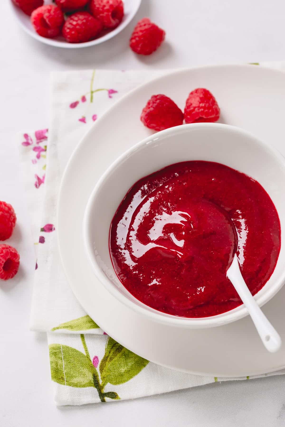 Seedless raspberry sauce in a white bowl.
