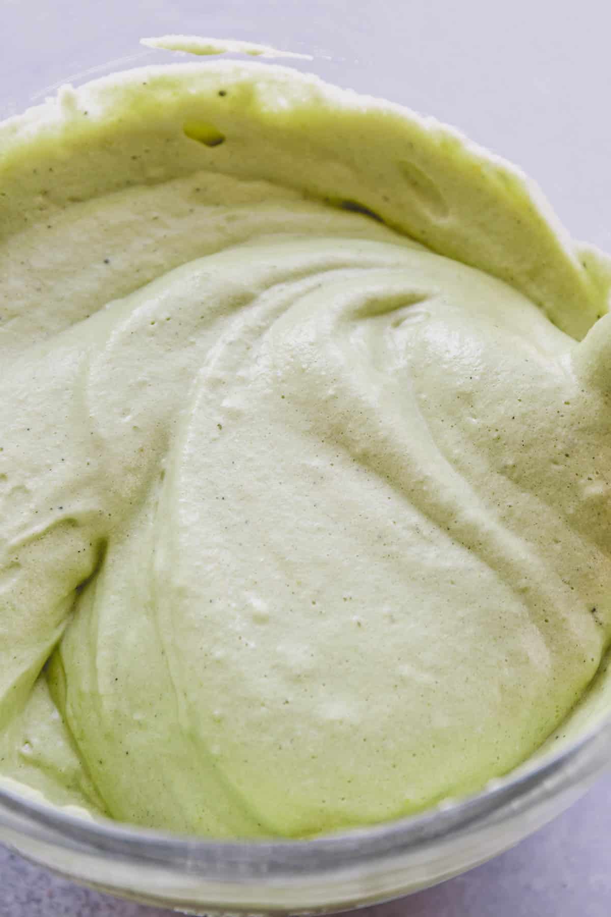 Fluffy pale green batter in a glass mixing bowl.