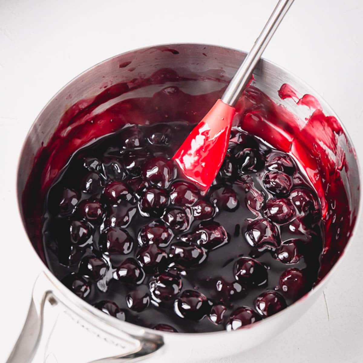 Cherry pie filling in a stainless steel saucepan.