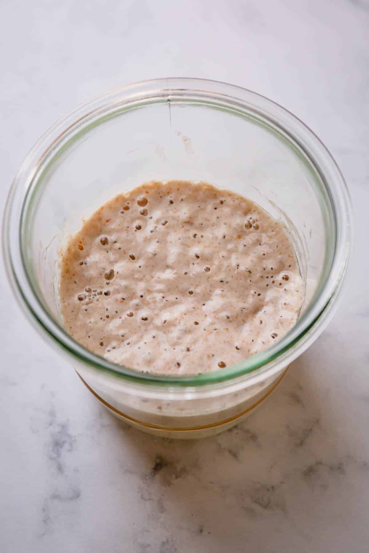 Active sourdough starter in a glass jar.
