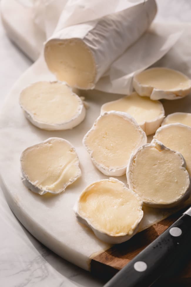 A log of brie sliced into discs.