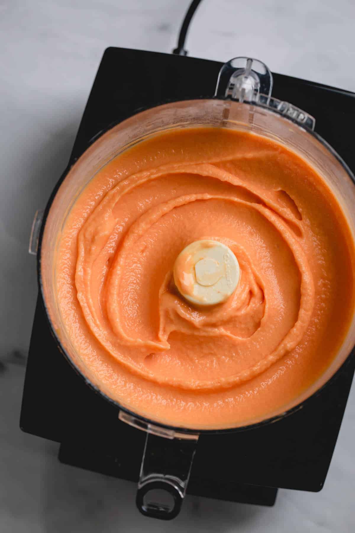 Smooth peach ice cream in a large food processor.