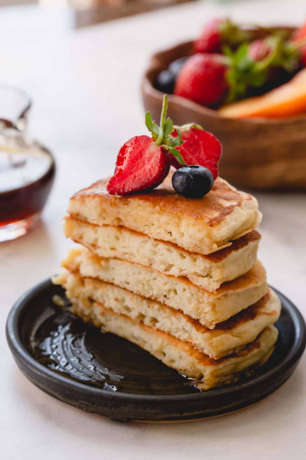 a stack of pancakes cut in half with fruit on top