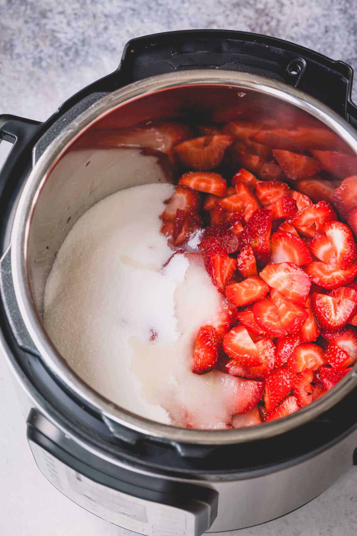 Sliced strawberries with sugar in an Instant pot.