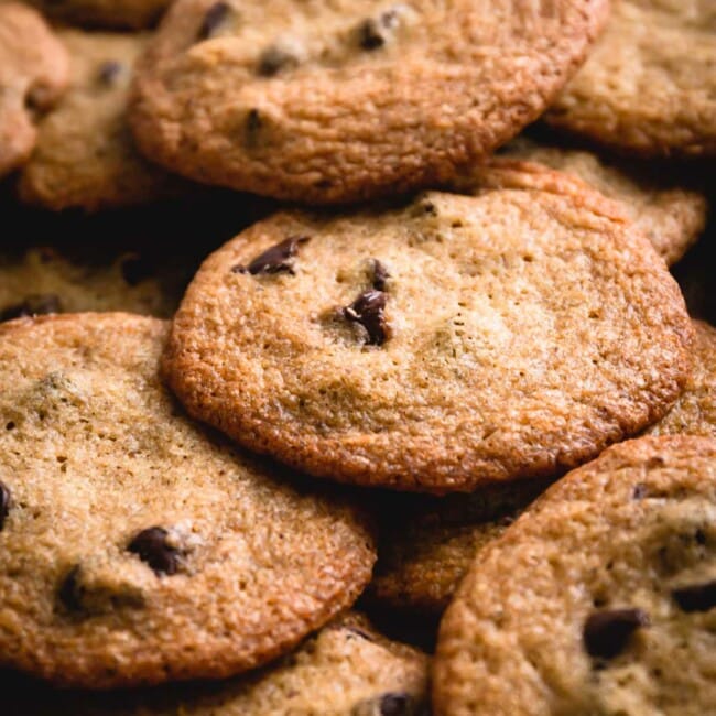 thin chocolate chip cookies in a pile.