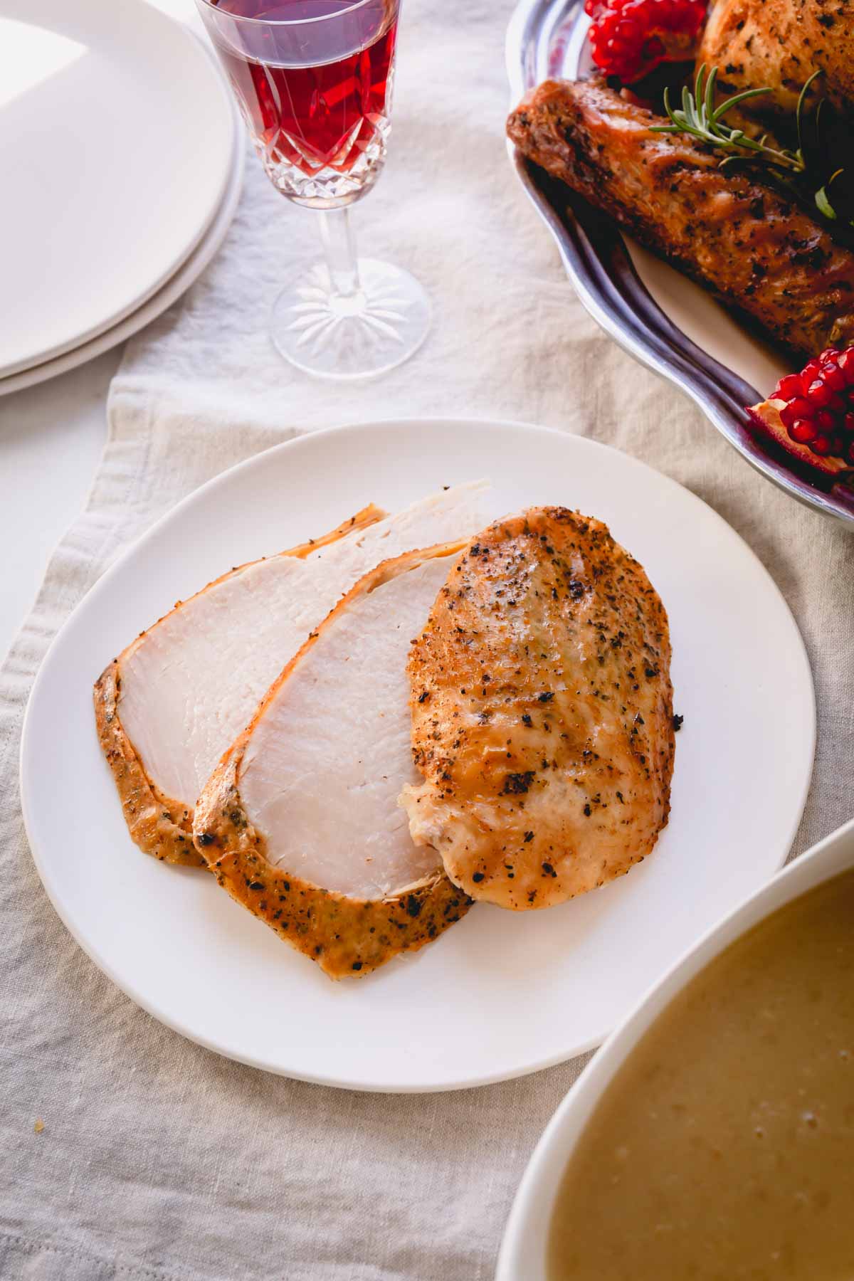 Three sliced turkey breast on a small white plate.