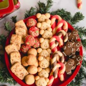 A round platter full of 6 varieties of of Christmas cookies.