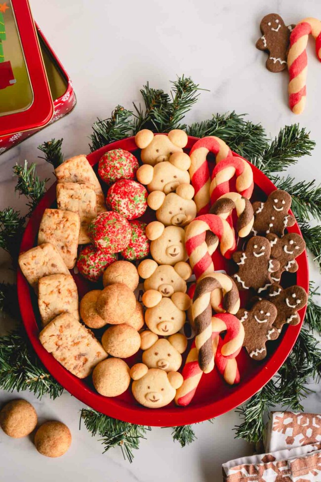 A round platter full of 6 varieties of of Christmas cookies.
