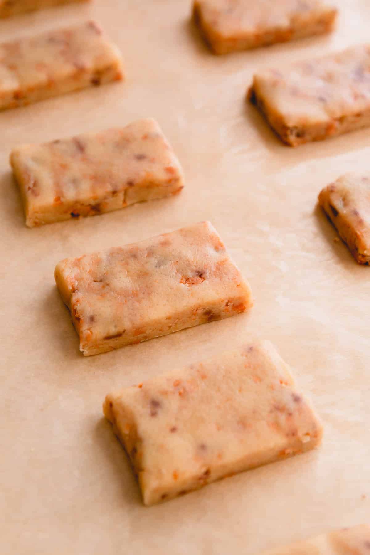 Butterfinger cookie dough cut into rectangles on a baking sheet.