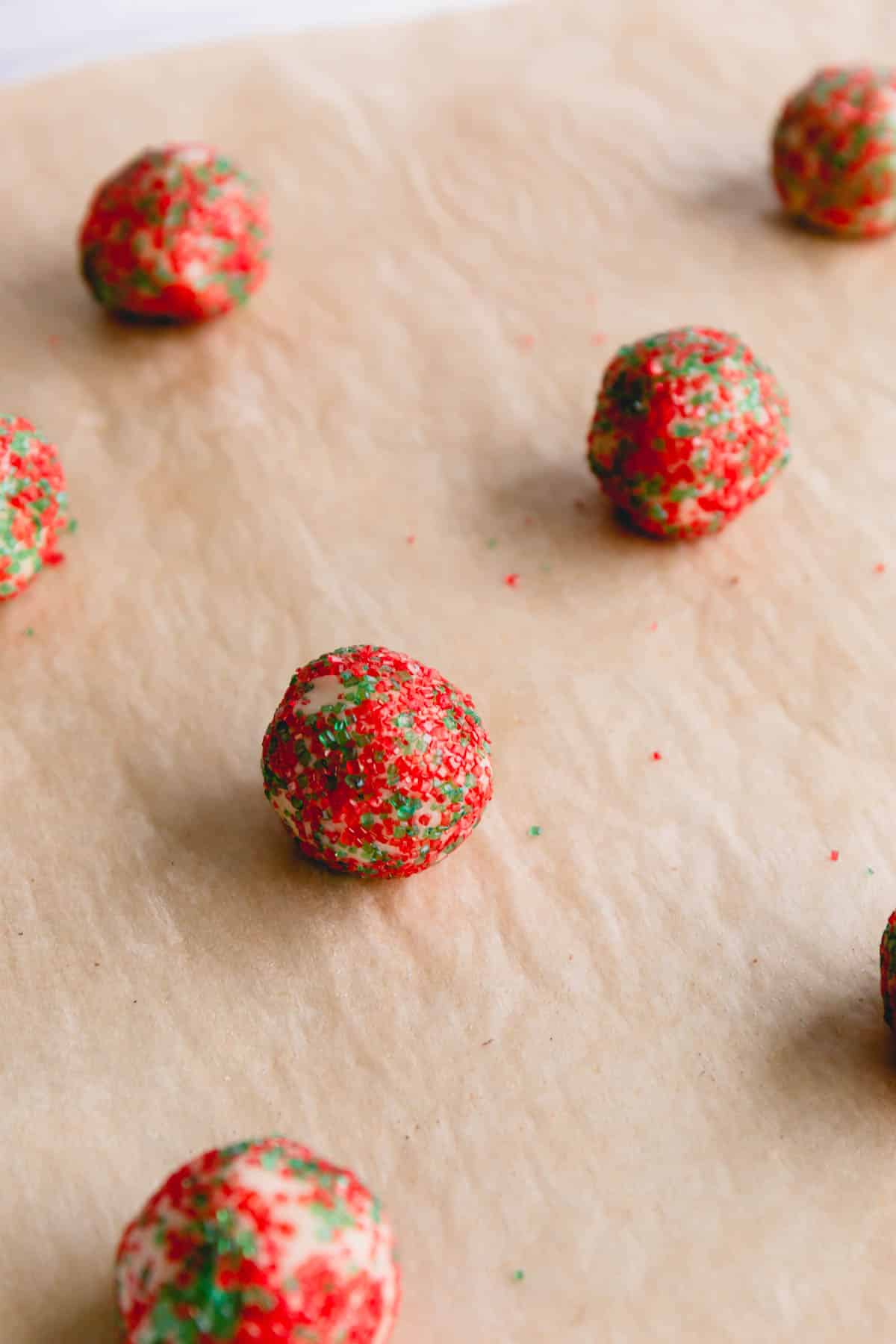 Small cookie dough balls rolled in a red and green sugars.