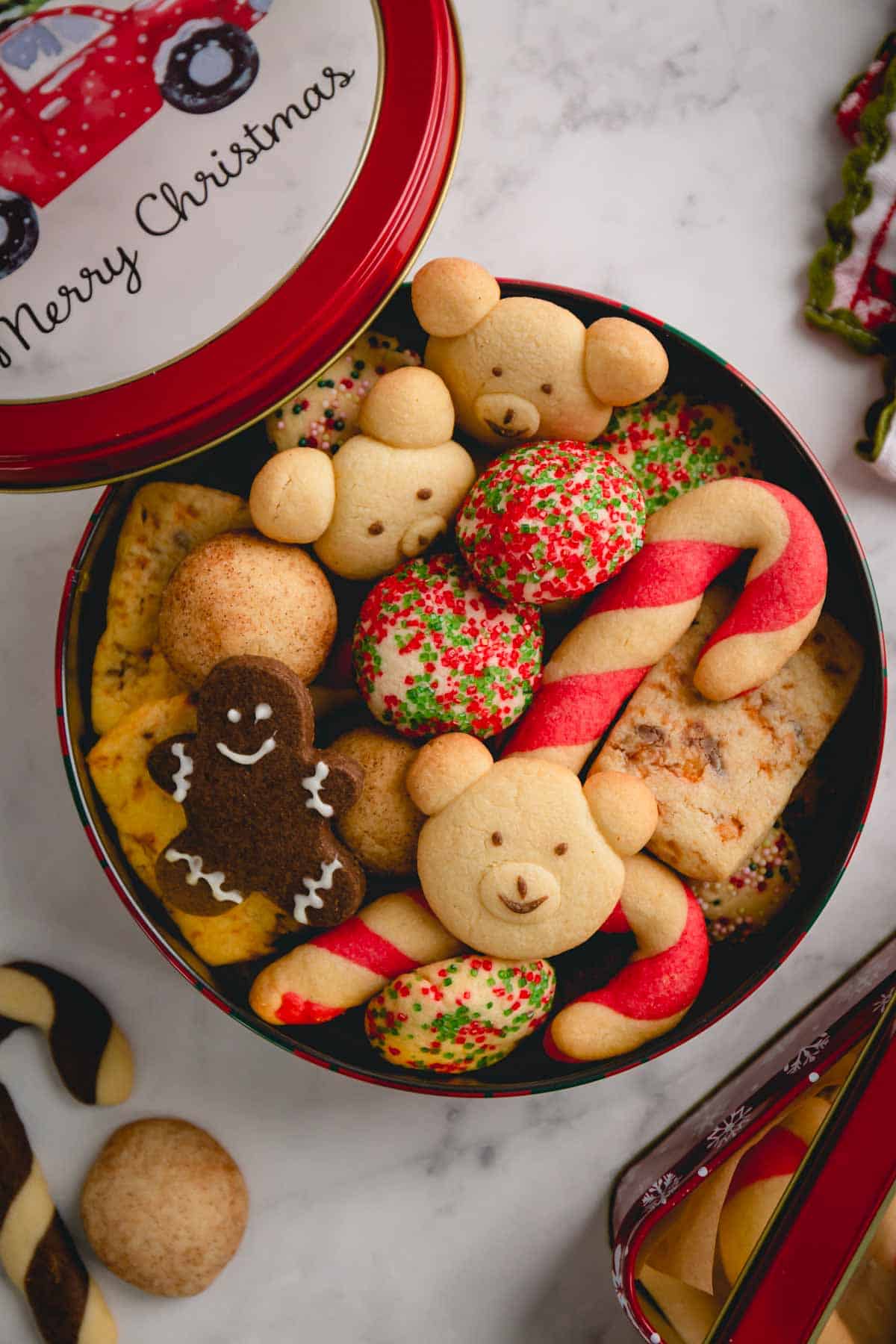 A round tin can of assorted Christmas butter cookies.