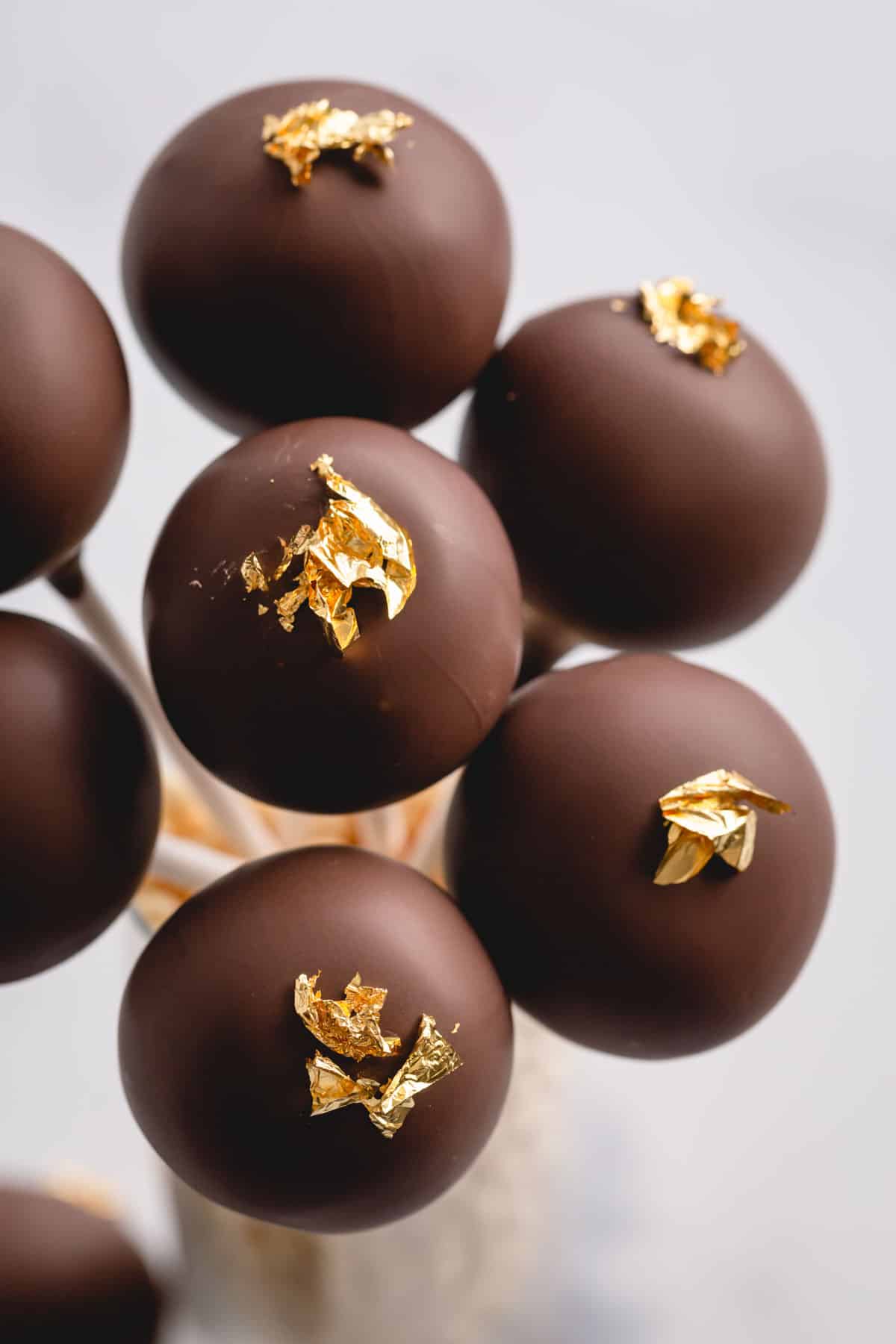chocolate cake pops with gold luster.