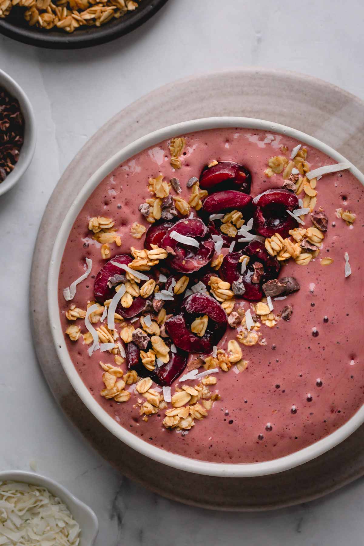 a black forest smoothie bowl with cherries on top.
