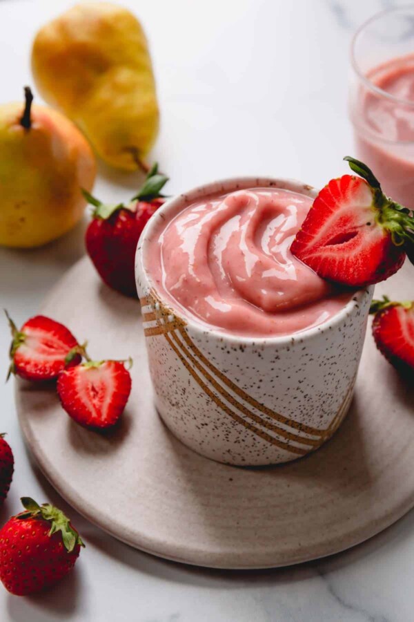 strawberry pear smoothie with a strawberry on top.