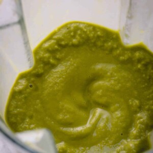 Close up image of a blended green smoothie in a blender.
