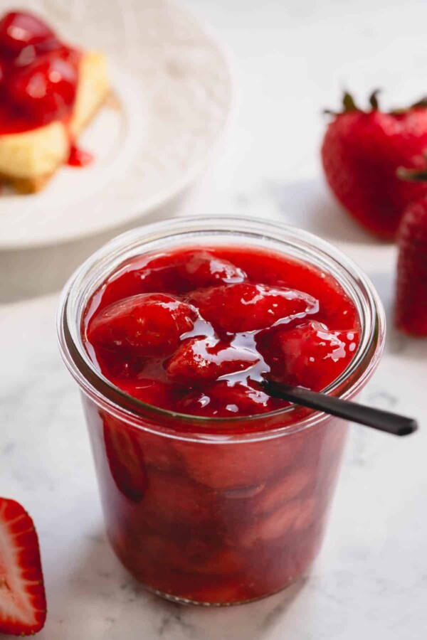 A glass jar of homemade strawberry sauce topping.