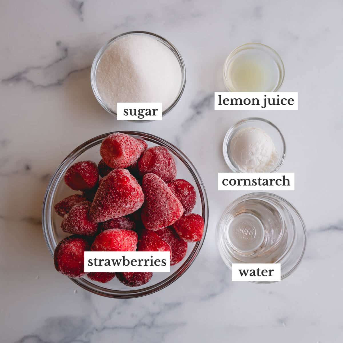 Bowls of frozen strawberries, sugar, lemon juice, cornstarch, and water to make strawberry sauce.