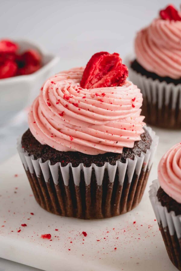 chocolate cupcake with strawberry buttercream and a strawberry.