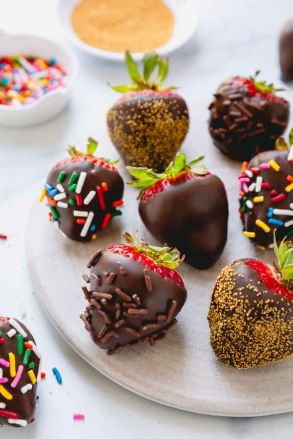 Chocolate covered strawberries coated with multi-color, chocolate, and gold sprinkles.