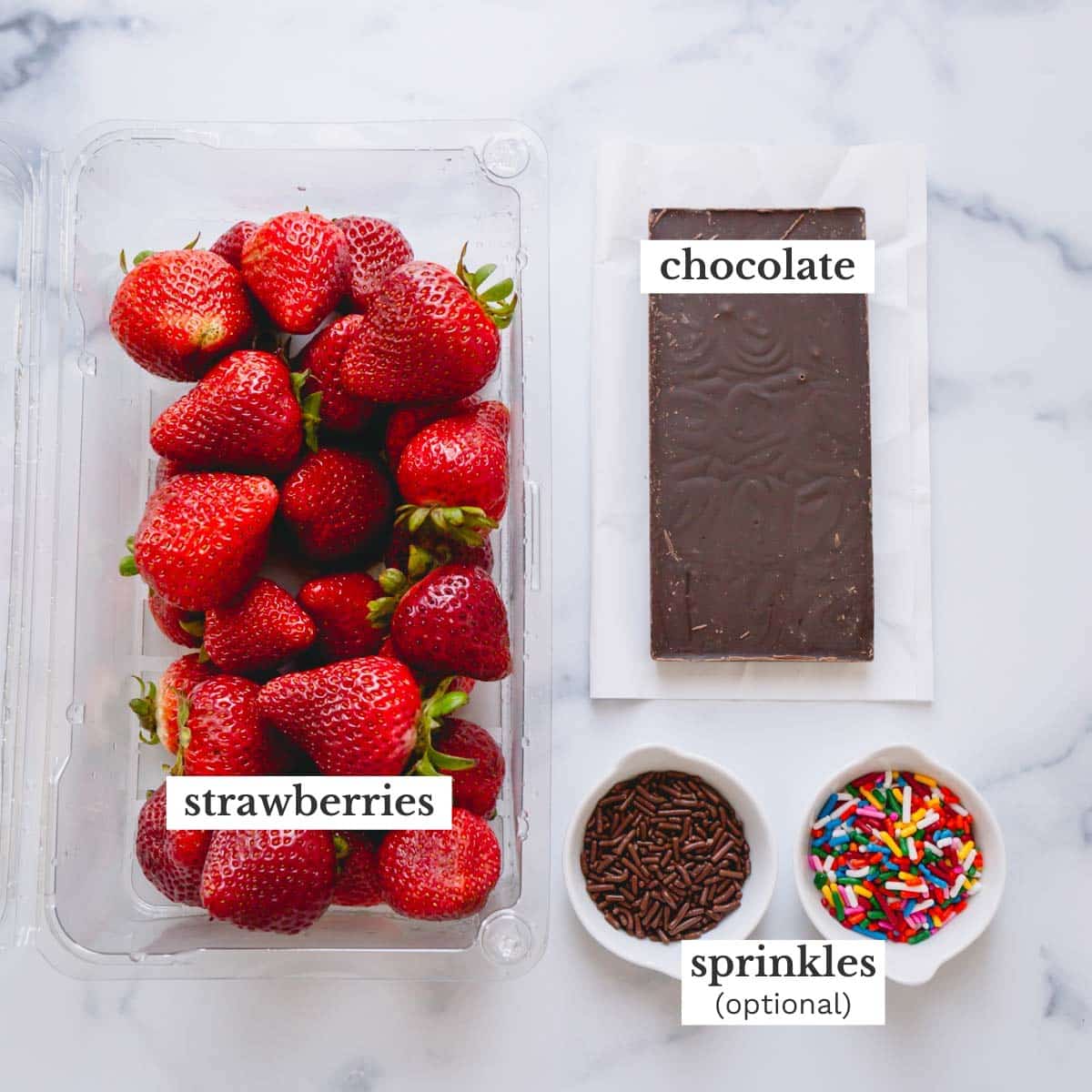 Chocolate, a bar of chocolate, a bowl of chocolate sprinkles, and a bowl of colorful sprinkles.