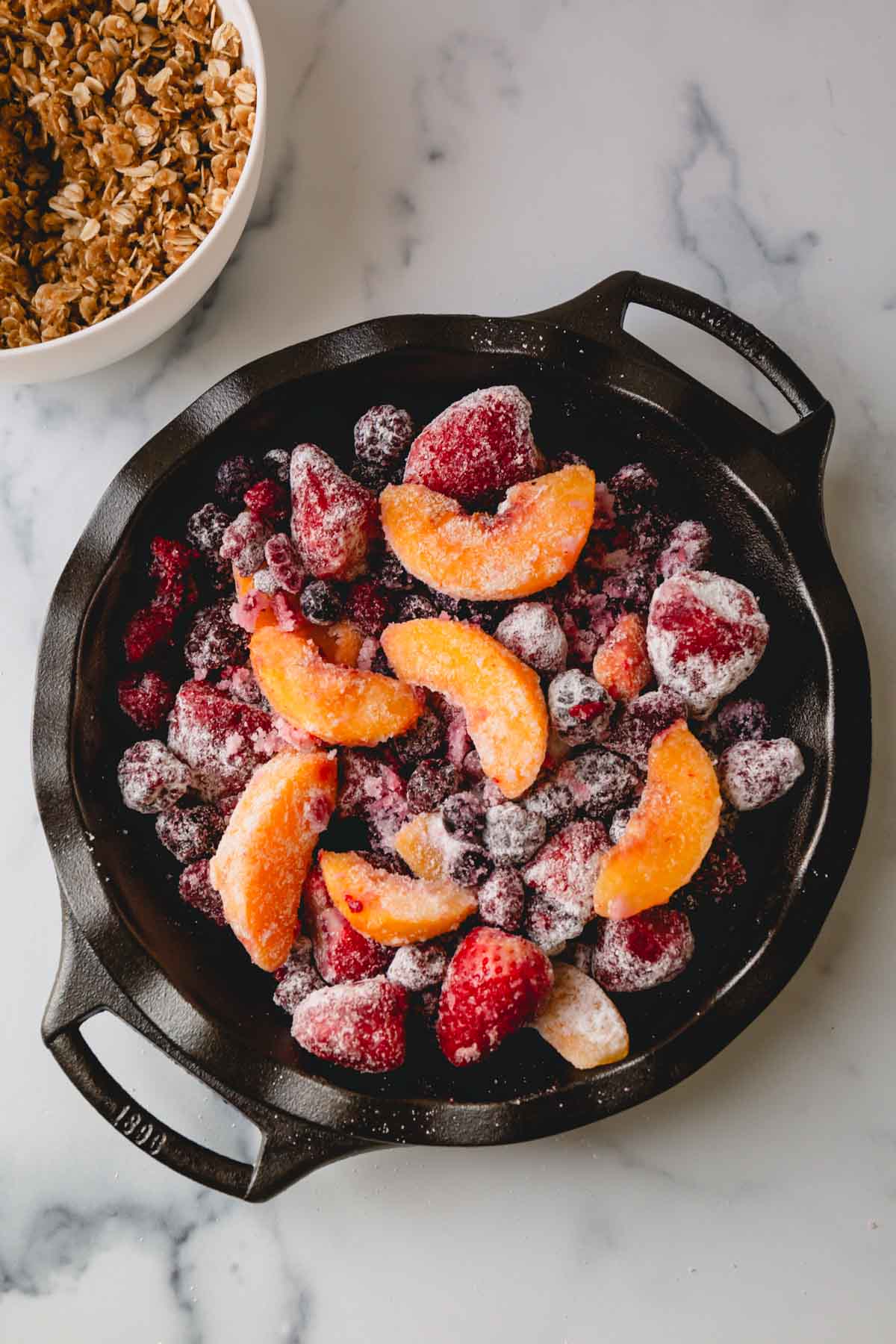 Overhead image of frozen mixed fruits in a large baking dish.