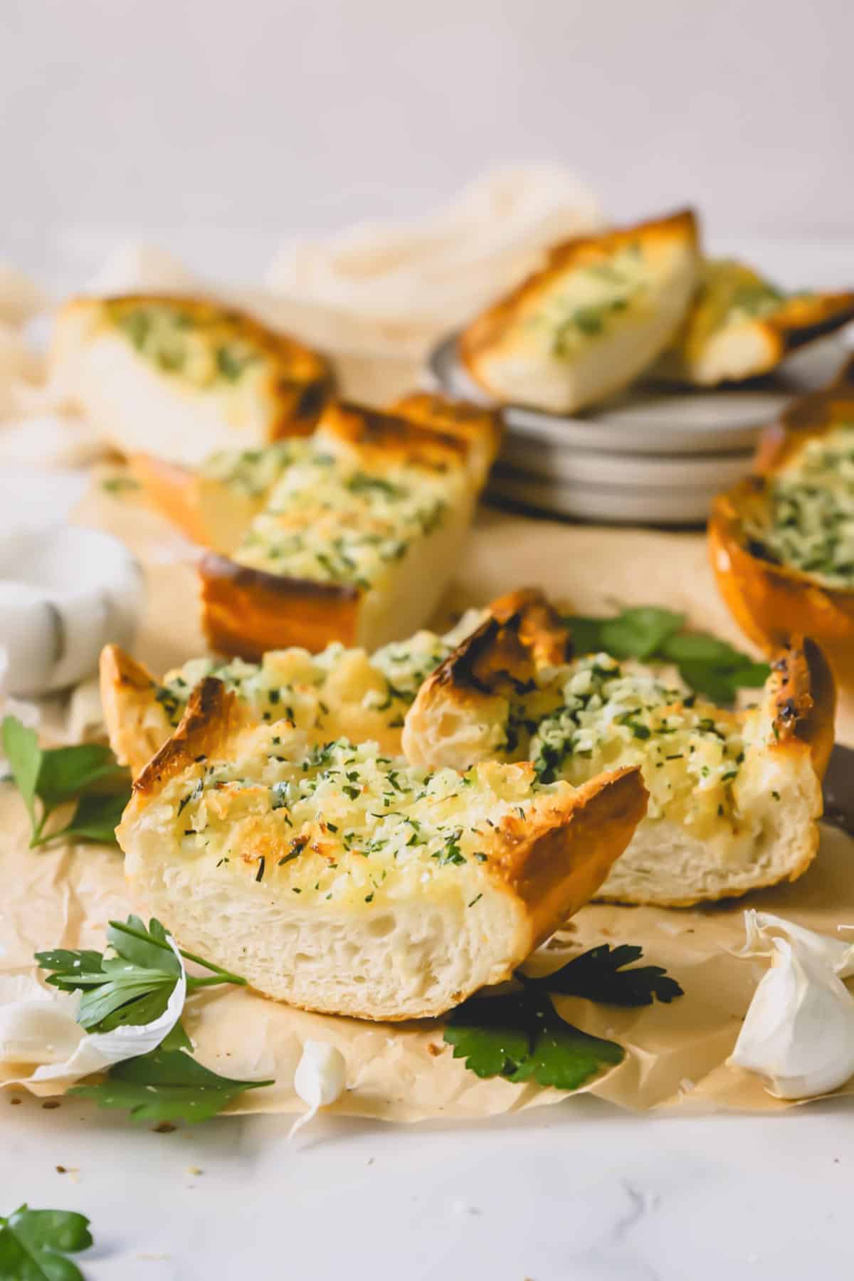 Pieces of garlic bread topped with an herbed butter spread.