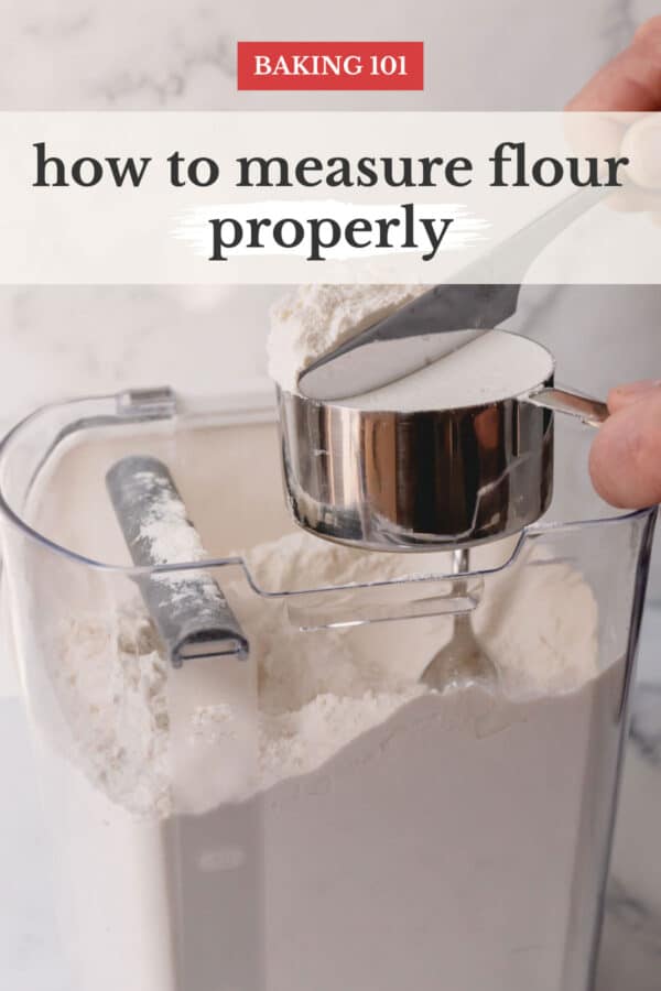 A container of flour with a measuring cup of flour leveled with a butter knife.