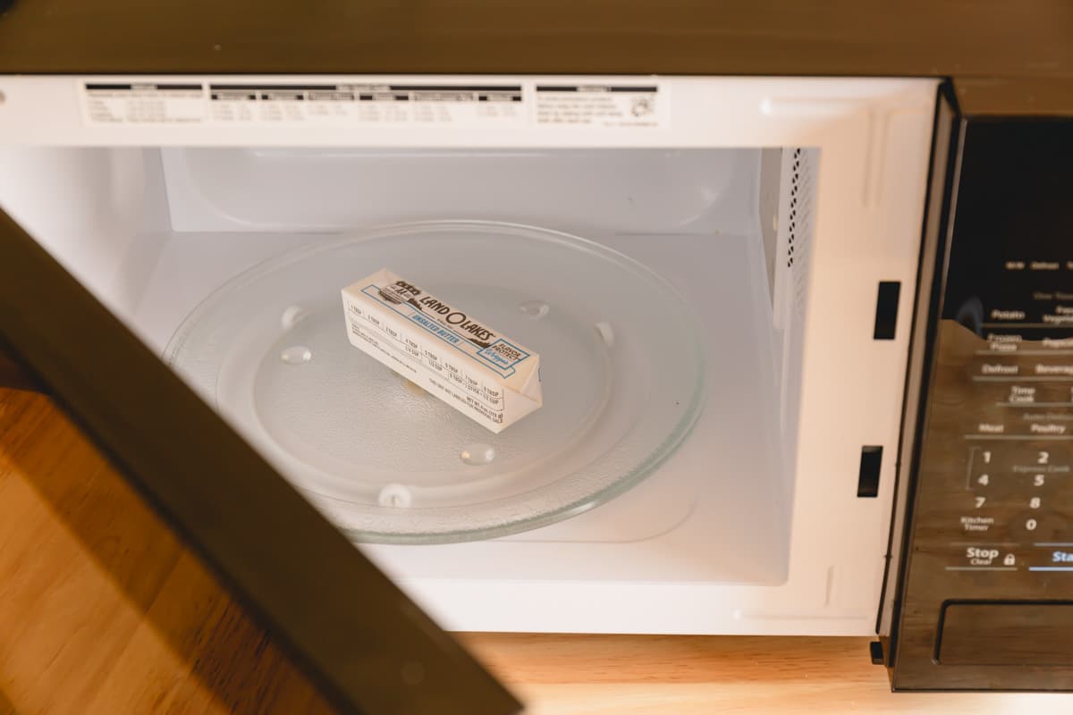 A stick of butter in the wrap in a microwave.