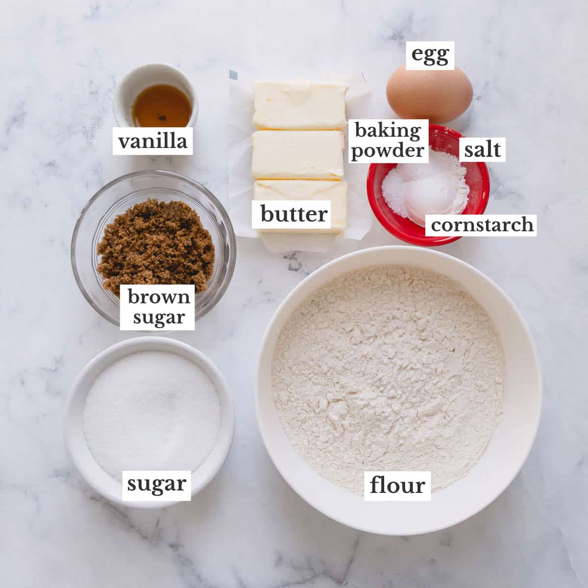 Ingredients for vanilla sugar cookies laid out in individual bowls.