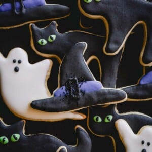 Halloween sugar cookies decorated as ghosts, cats, and witch hats.