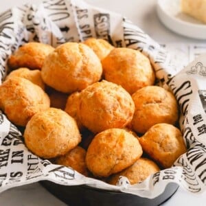 A platter of golden round cheese puffs piled up.