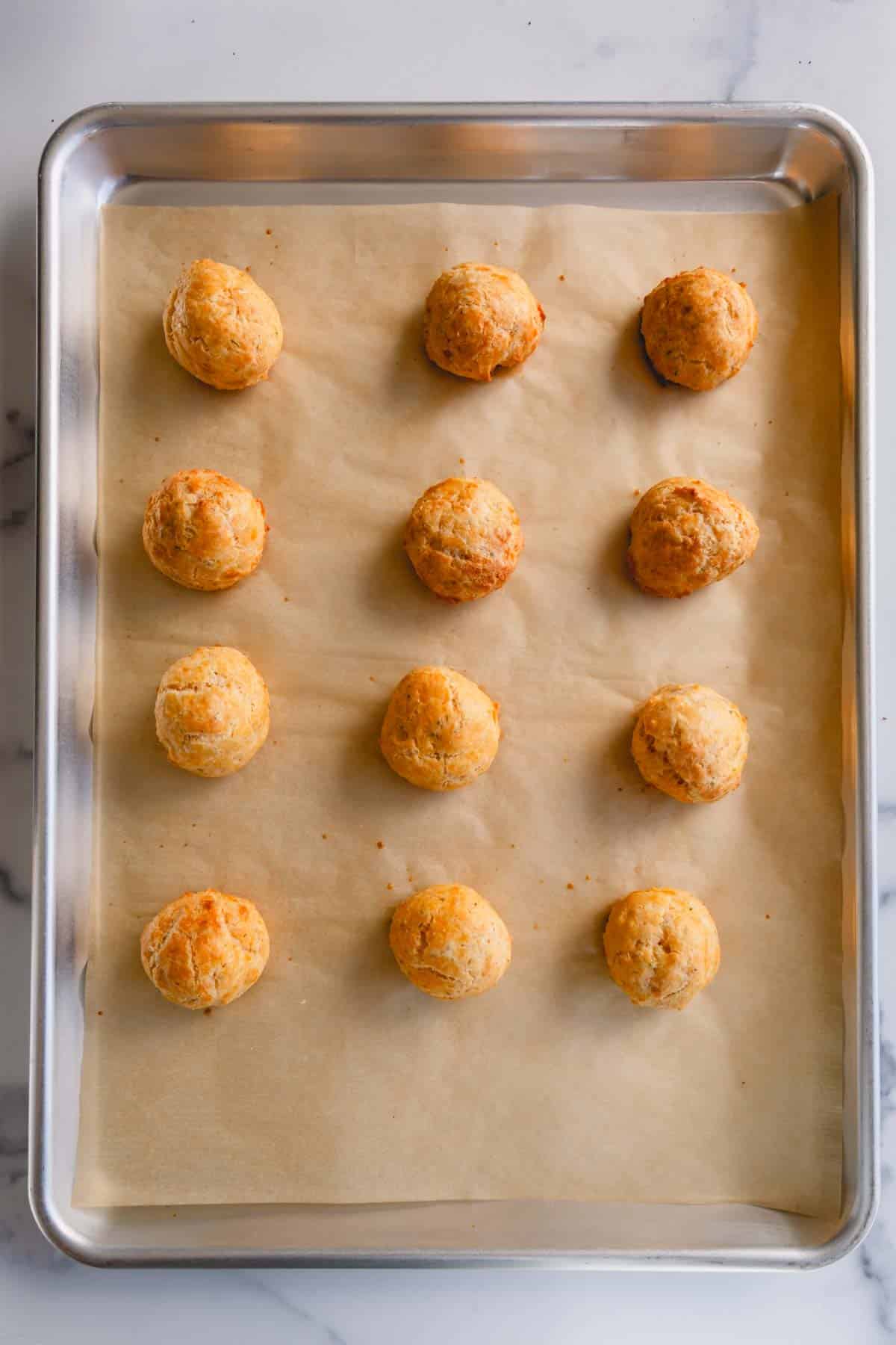 Baked cheese puffs on a baking sheet.