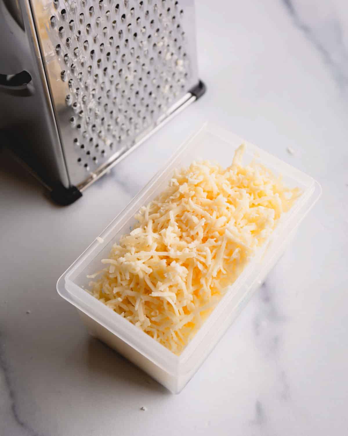Freshly grated aged havarti cheese on a fine grater.