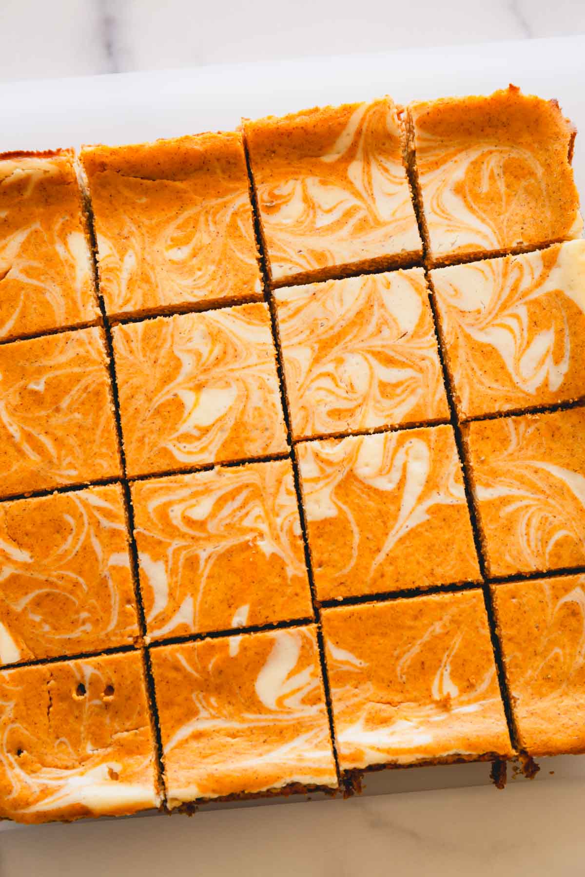 Overhead image of squares of pumpkin cheesecake bars.
