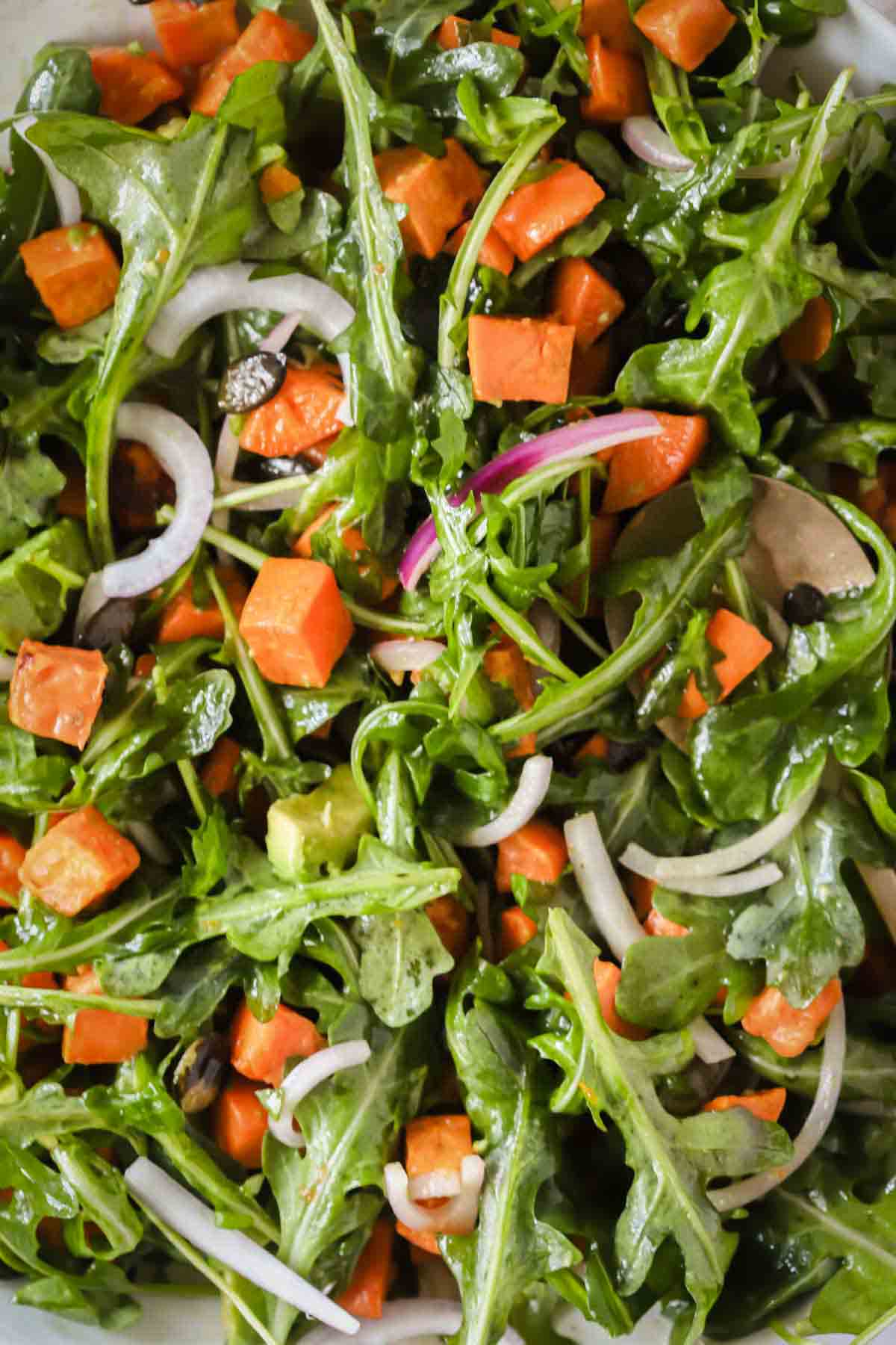 Close up image of a sweet potato salad dressed with dressing.