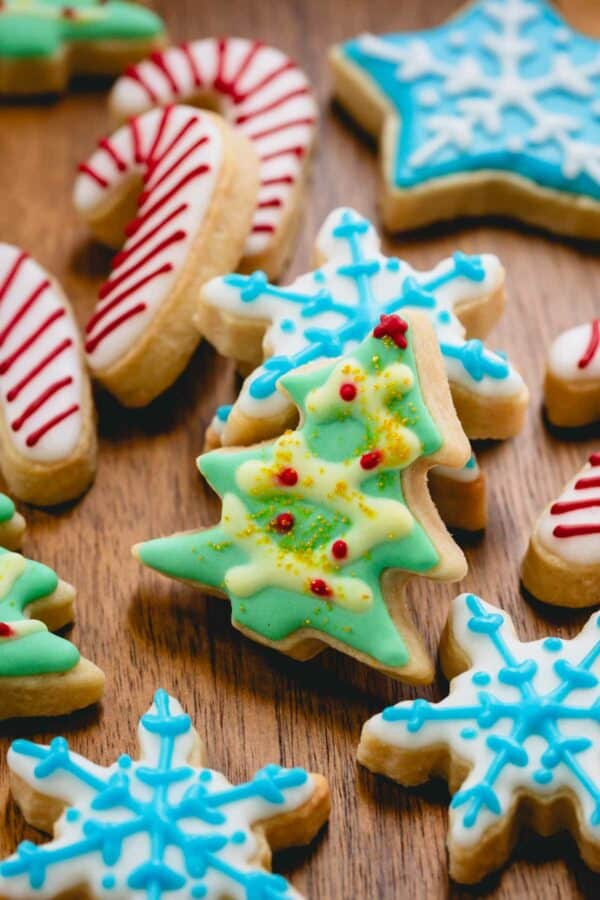Iced Christmas sugar cookies in the shape of candy canes, Christmas trees, and snowflakes.