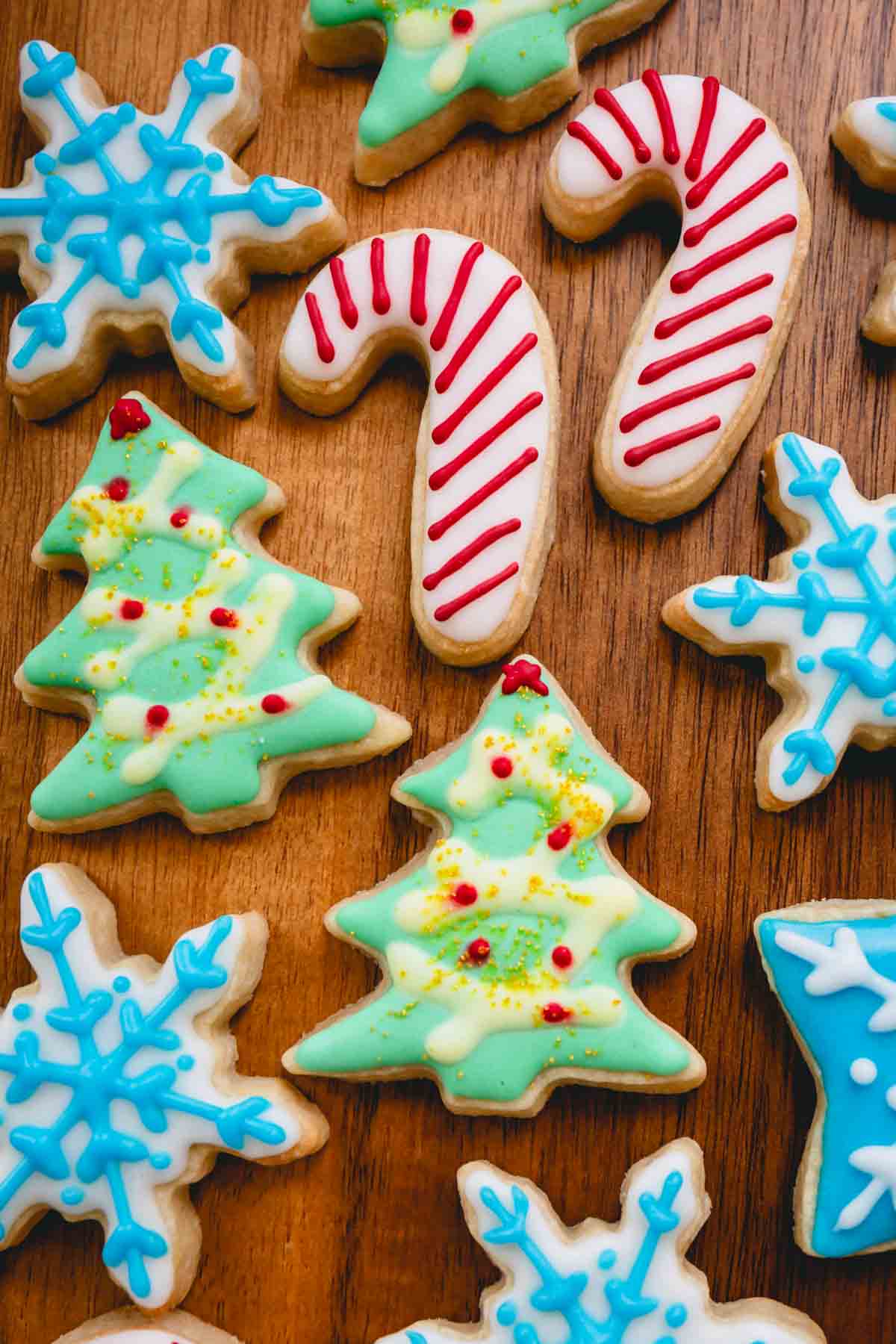 Decorated Christmas sugar cookies in the shape of candy canes, Christmas trees, and snowflakes.